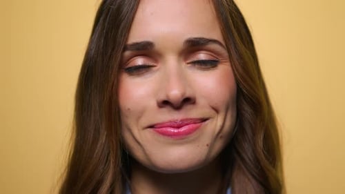 Cheerful Woman Face On Yellow Background. Close Up Happy Woman Smiling At Camera In Slow Motion. ...