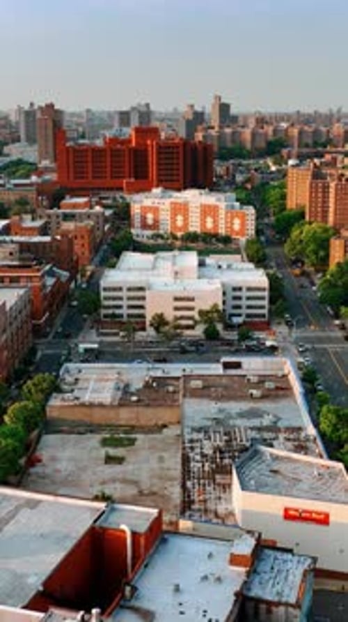 Diverse blocks of flats in the cityscape of New York. Drone footage above the roofs at sunset.