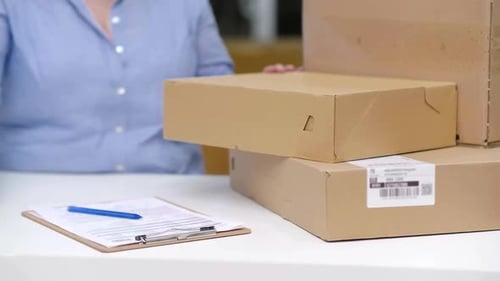 Person Scanning Packages at Brightly Lit Desk