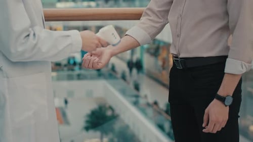 Unknown Medical Worker Doctor in Office Hospital Clinic Measures Temperature of Male Hand of