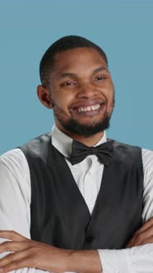 Vertical Video Confident Cheerful Hotel Concierge Staff Poses with Arms Crossed in Studio