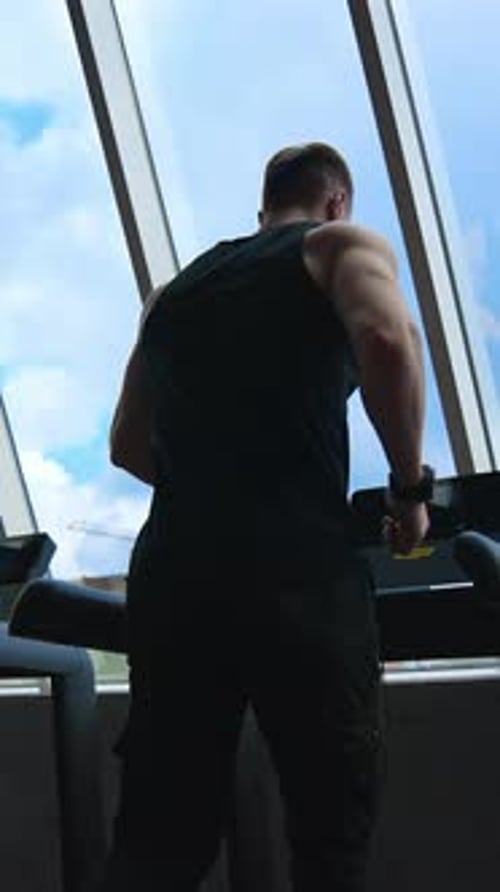 Man running on the treadmill. Athletic man running on treadmill in fitness gym