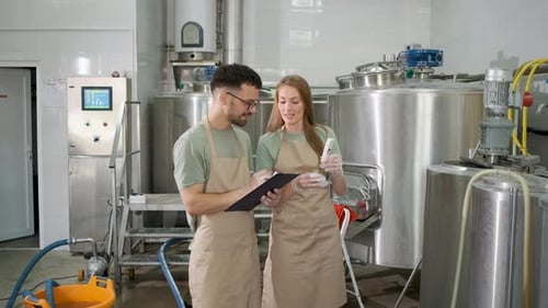 Homme et femme travaillant dans une brasserie artisanale vérifiant le pH de la bière.