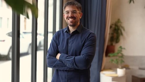 Portrait of a successful entrepreneur standing in a modern office, exuding confidence with his arms