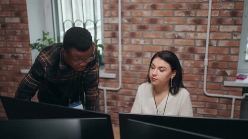 Black Man and Caucasian Woman Flirting in Office Colleagues Discussing Project Looking at Computer