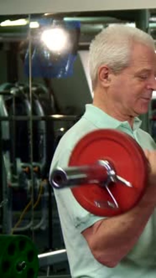 Senior Adult Lifts Weights in Gym