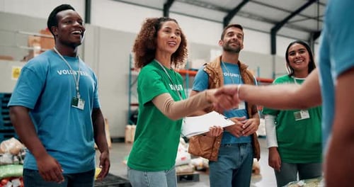Diverse Volunteers Shaking Hands in Warehouse