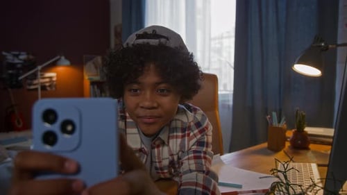 Young Person Using a Mobile Phone at Desk