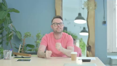 Man with Glasses Thinking at Table Indoors
