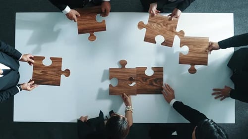 Top view of businesspeople putting jigsaw together at meeting room. Directorate.