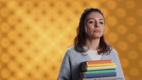 Portrait of Upbeat Woman Holding Pile of Books Studio Background