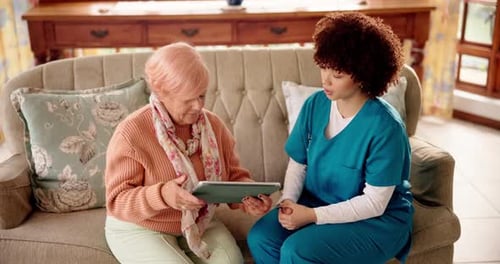 Senior Woman Using Tablet With Caregiver