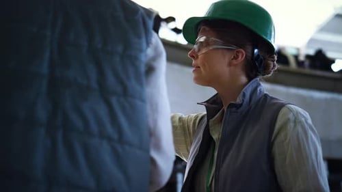 Un travailleur parle en direct avec un collègue au salon de production de traite en gros plan. Femme concentrée