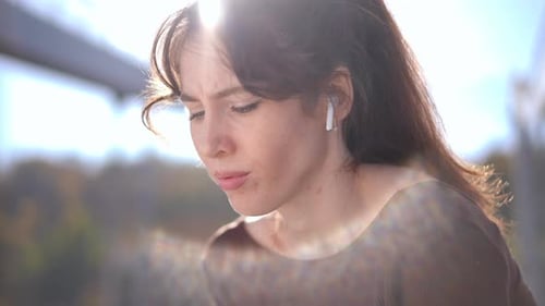 Young Woman with Earbuds in Urban Setting