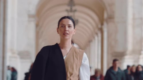 Confident Businesswoman Walking Through Arched Corridor in City