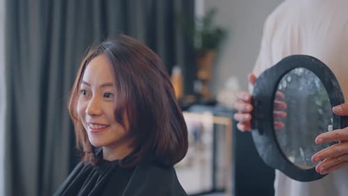 Woman Enjoys Haircut at Beauty Salon