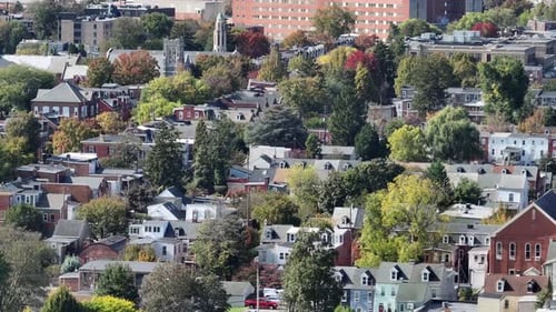 Row of houses and townhouses with downtown and church in background. Aerial wide shot. Multi