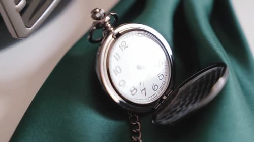 Vintage-Taschenuhr, die auf grünem Stoff ruht