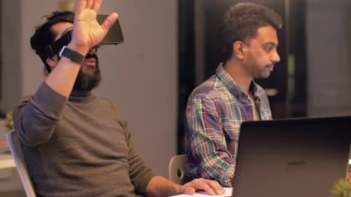 Man Using VR Headset in Workplace with Colleague