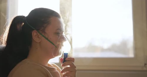 Sick Woman Inhaling Mist From Nebulizer Mask - Treatment For Respiratory Diseases. - side view, clos