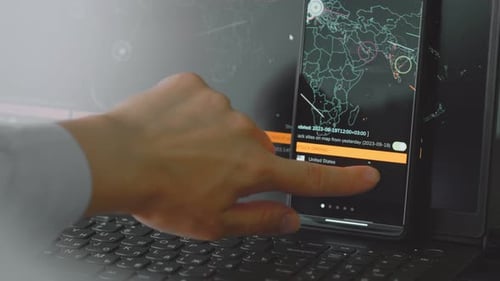 Hand Interacting with Cybersecurity Data on Phone and Laptop