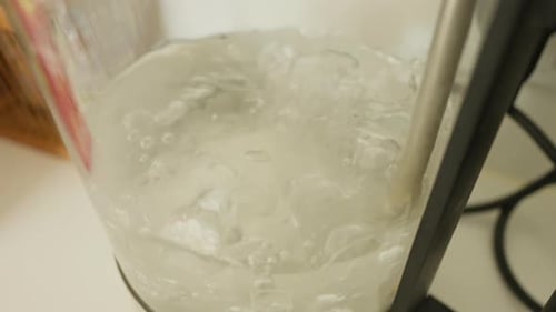 Close Up of Water Boiling in Glass Container