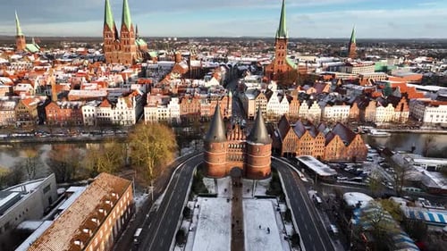 Push-in ascending aerial shot of the Holstentor gate and the historic old town of Lübeck, Germany, w