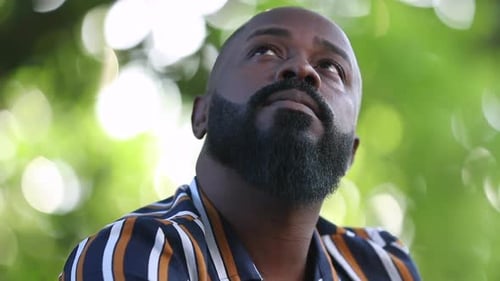 Thoughtful pensive black African man outside at park