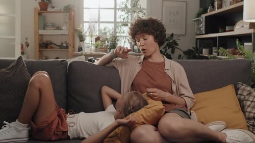 Woman talking with child on sofa at home