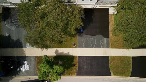 Workers Sealcoating Driveways From Aerial Birds Eye View