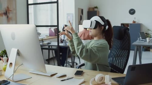 Female Software Developer Testing Mobile App in Virtual Reality Headset