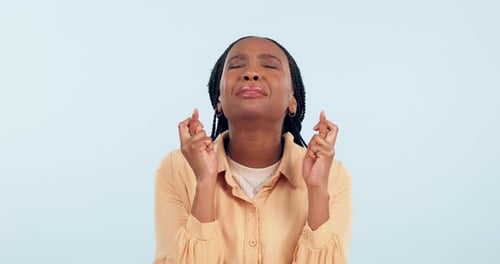 Hope, woman and worry with fingers crossed in studio for nervous results