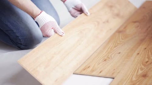 Repair, Building, Floor and People Concept - Close Up of Man Installing