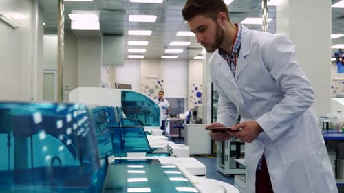Scientist Using Tablet Inspecting Medical Lab Equipment