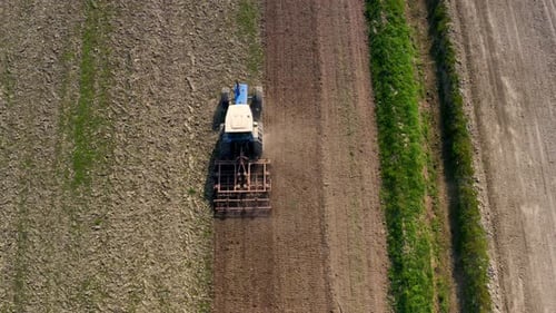 drone following a tractor working a field from above