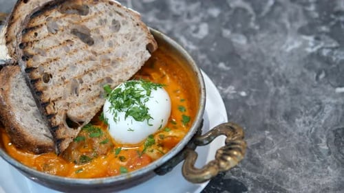 Enjoy Delicious Shakshuka with a Poached Egg and Perfectly Toasted Grilled Bread