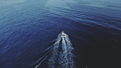 Drone shot of fishing boat tilting up and moving backwards