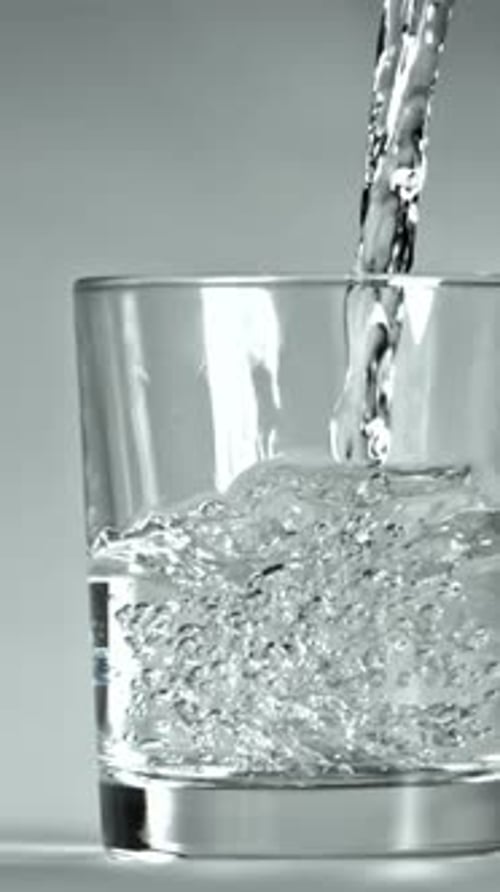 Wasser wird in ein Glas gegossen, das mit einer Hochgeschwindigkeitskamera mit 1000 Bildern pro Sekunde gefilmt wurde