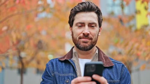 Happy Man Using Phone Outdoors During Autumn