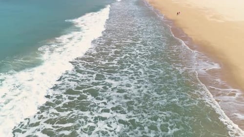 Aerial View of Waves Crashing on Sandy Beach