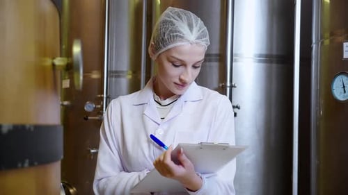 Winzerin überprüft und untersucht die Weinherstellung im Weingut in der Fabrik.