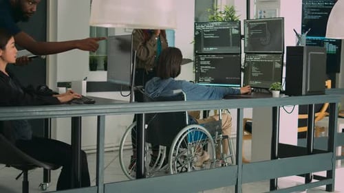 Asiatischer Programmierer mit körperlicher Behinderung arbeitet mit afroamerikanischen Entwicklern zusammen