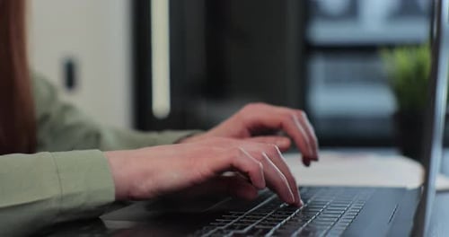 Hands Typing on Laptop Computer Keyboard at Desk