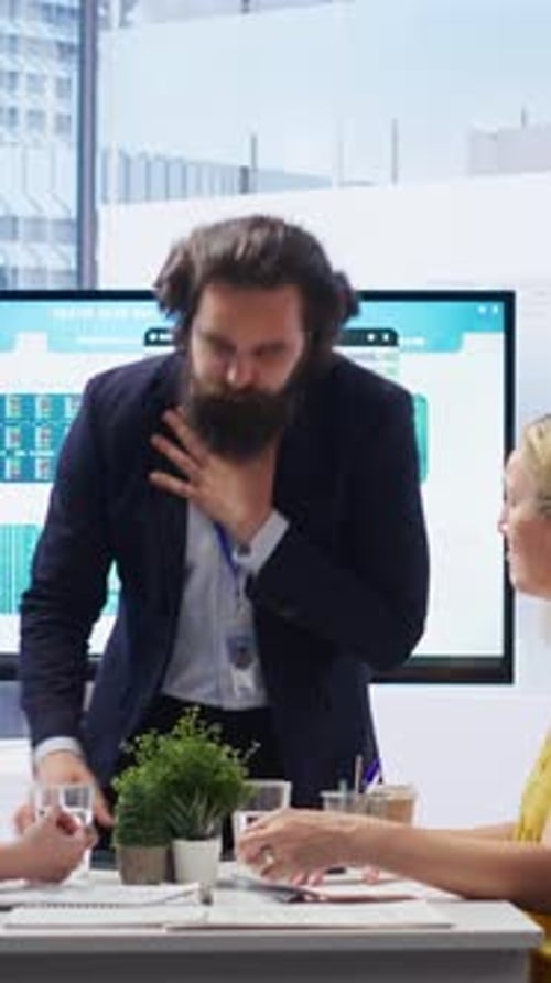Vidéo verticale : un employé s'étouffe au bureau aidé par un collègue effectuant une manœuvre de Heimlich