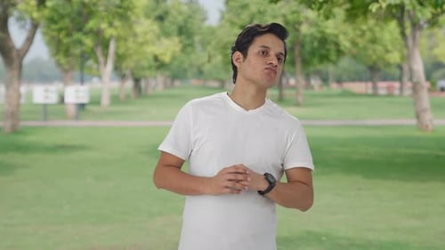 Man Checking Smartwatch Time Outdoors in Park