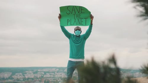 Activist Holding Save The Planet Sign Above City