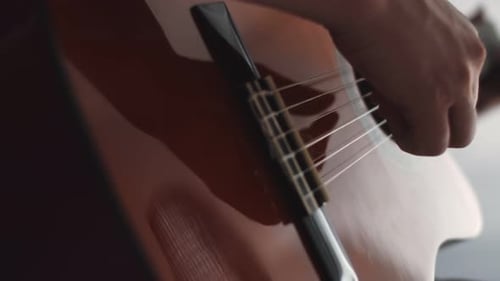 Closeup of an Acoustic Guitar Played By Male Musician in Studio