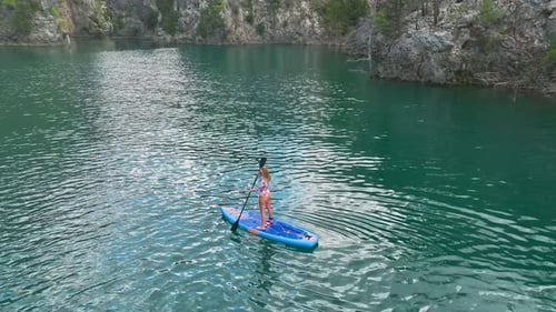 Aerial View Paddleboarding Adventure in a Large Green Canyon Exploring Nature