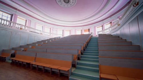 Beautiful conference hall with empty seats. Modern auditorium with wooden desks for lectures.
