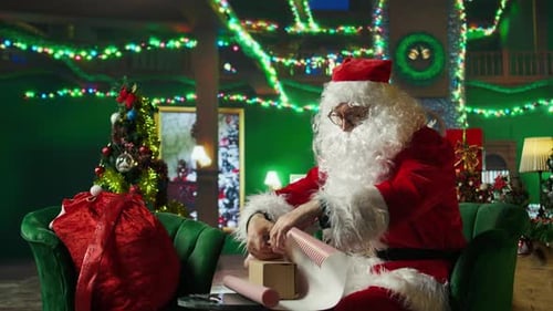 Santa Wrapping Presents in a Christmas Decorated Room